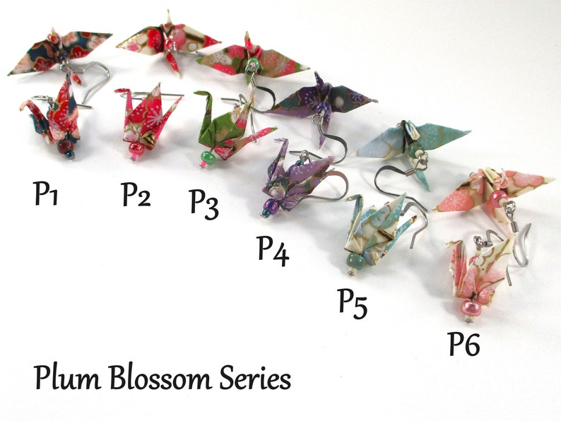 Op de afbeelding: Zes paar origami-kraanvogel oorbellen in verschillende kleuren en patronen, waaronder rood, groen, paars, blauw en roze. De oorbellen zijn gelabeld van P1 tot en met P6. De tekst "Plum Blossom Series" staat onderaan de afbeelding.