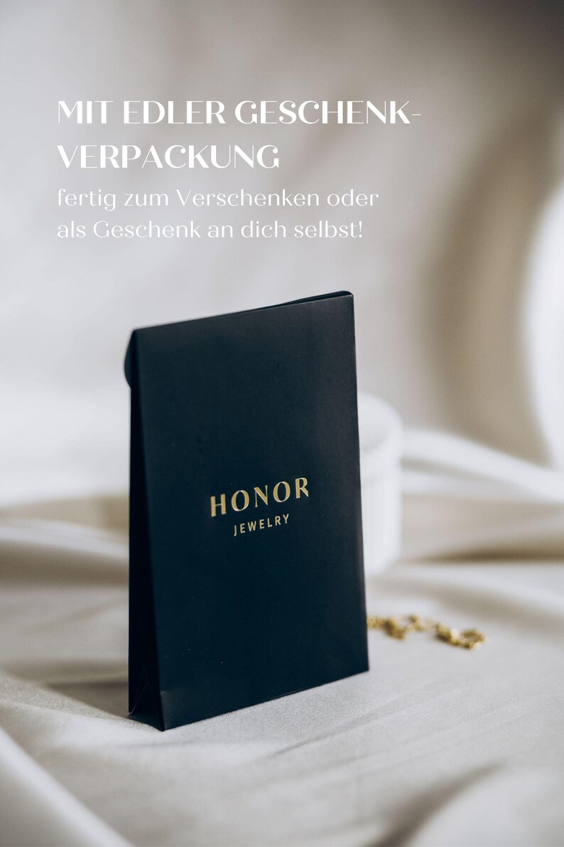 May include: A black gift box with gold lettering that reads "HONOR JEWELRY". The box is on a white surface.
