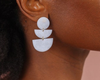 Pair of handmade earrings all white and slightly marbled by dehisstudio