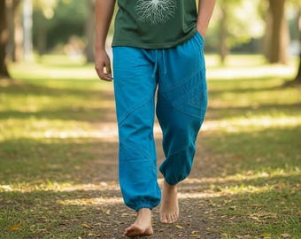 May include: A dark green short-sleeved t-shirt featuring a white line-art graphic of a coniferous tree with visible roots, paired with bright blue loose-fitting trousers that have an elasticated waistband and cuffed ankles.