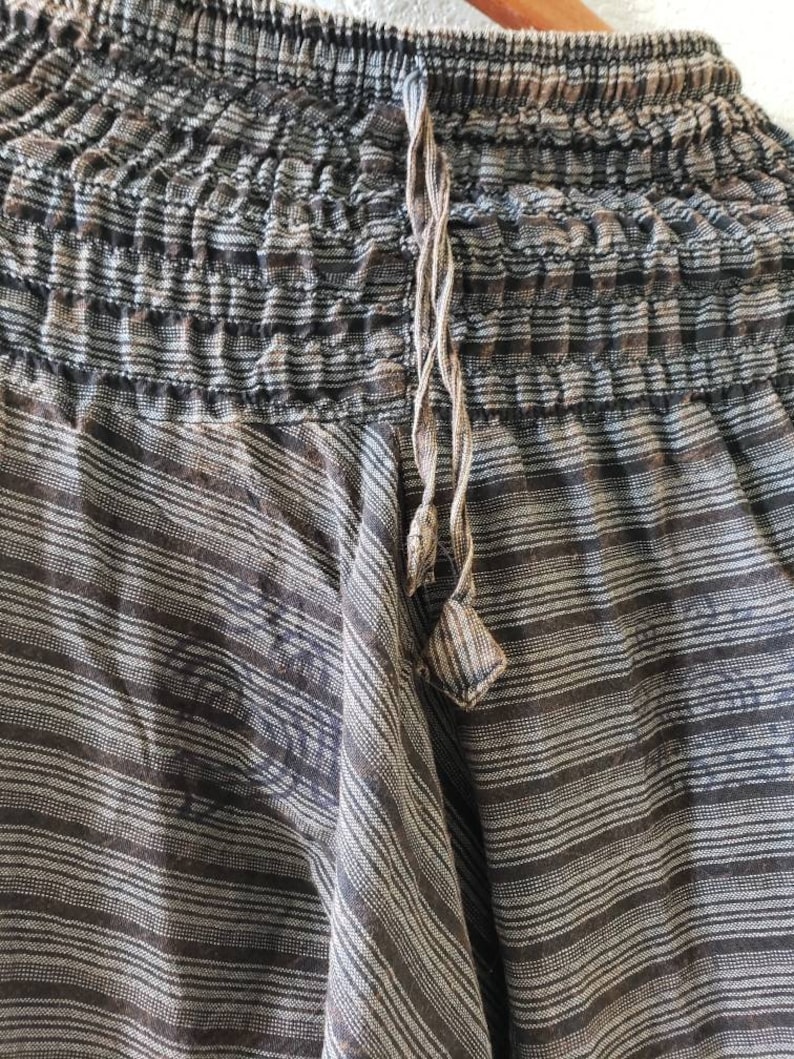May include: Black and white striped pants with a drawstring waist. The pants are made of a soft, lightweight fabric and have a relaxed fit.