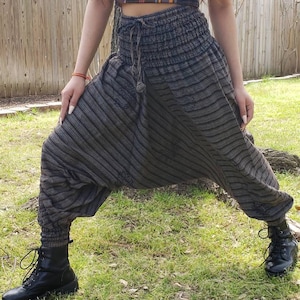 May include: Gray and black striped harem pants with a drawstring waist and a tassel. The pants are made of a soft, comfortable fabric and have a relaxed fit.