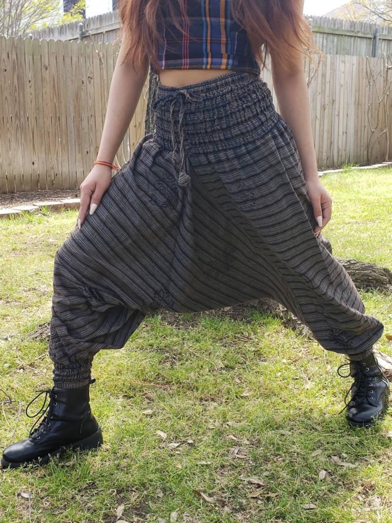May include: Gray and black striped harem pants with a drawstring waist and a tassel. The pants are made of a soft, comfortable fabric and have a relaxed fit.