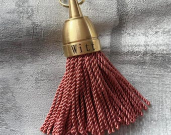 Gold-colored Philadelphia hotel keychain with pink tassel | Brass keychain with tassel