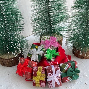 Op de afbeelding: Een verzameling ingepakte kerstcadeaus in een rode fluwelen tas. De cadeaus zijn versierd met verschillende patronen en linten, waaronder groen, rood, wit en goud.