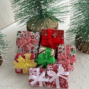 May include: Eight miniature red and white gift boxes with various coloured ribbons and bows. The boxes are decorated with snowflakes and other festive designs.
