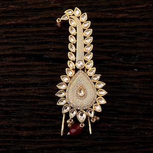 Op de afbeelding: Een gouden haarsnoer met een traanvormig ontwerp. De versiering is versierd met wit emaille en heldere strass steentjes. De versiering heeft twee pinnen om hem in het haar te bevestigen.