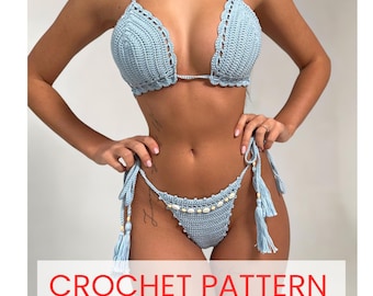 Puede incluir: Un conjunto de bikini de ganchillo azul claro que incluye un top estilo halter con bordes festoneados y una braga a juego con lazos laterales, borlas y una fila de pequeñas conchas blancas. El texto CROCHET PATTERN es visible abajo.