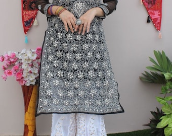 May include: A black and silver embroidered kurta with a sheer overlay. The kurta features a floral pattern and is paired with white palazzo trousers.