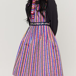 Puede incluir: Un vestido de rayas de colores con un cinturón bordado con flores. El vestido tiene un corpiño ajustado y una falda completa.