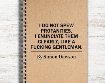 May include: A spiral-bound notebook with a tan cover. The cover features the text: "I DO NOT SPEW PROFANITIES. I ENUNCIATE THEM CLEARLY, LIKE A FUCKING GENTLEMAN. By Simon Dawson."