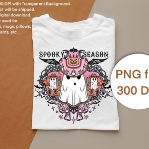 May include: White t-shirt with a "Spooky Season" graphic. The design features a ghost wearing a cowboy hat, surrounded by cacti, revolvers, and stars. The graphic is in a decorative frame with the text "Spooky Season" at the top. A PNG file with 300 DPI is also shown.