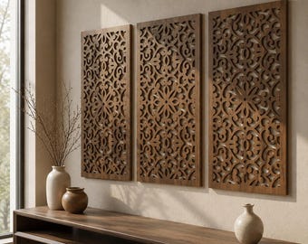 May include: Three rectangular wall panels made of dark brown wood featuring intricate, laser-cut symmetrical patterns. The panels are mounted side-by-side on a wall, displaying a repeating floral-inspired motif with openwork details throughout.