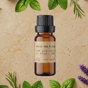 May include: A small amber glass bottle with a black cap containing a white tea and sage 100% pure essential oil blend. The label features the text white tea & sage, 100% pure essential oil blend | 15ml, and the brand name aire candle.
