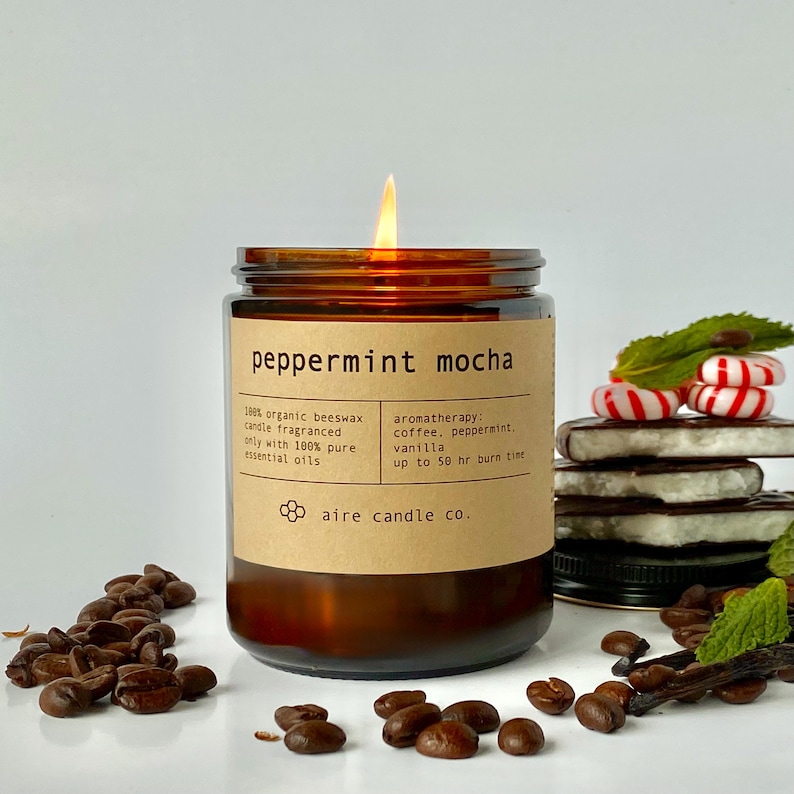Peppermint Mocha candle surrounded by coffee beans, peppermint and vanilla.