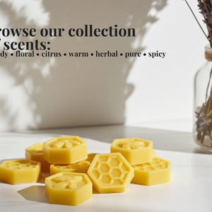 May include: A collection of yellow, hexagonal beeswax melts with embossed honeycomb and bee patterns. The text reads: browse our collection of scents: woody &bull; floral &bull; citrus &bull; warm &bull; herbal &bull; pure &bull; spicy. A glass vase with dried lavender is nearby.