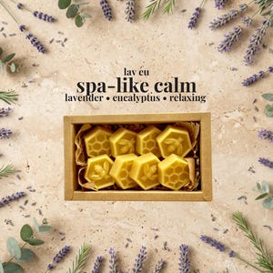 May include: A rectangular cardboard box containing eight yellow hexagonal wax melts, each featuring embossed bee or honeycomb patterns. The text "lav eu spa-like calm lavender &bull; eucalyptus &bull; relaxing" is printed in black above the box.