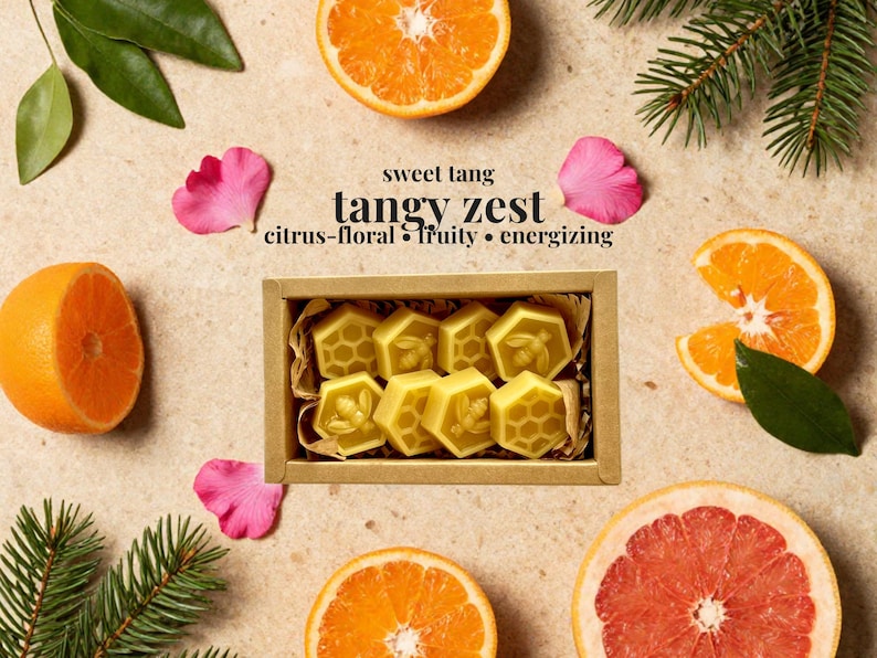 May include: A rectangular cardboard box containing six yellow wax melts shaped like hexagons, featuring embossed bee and honeycomb patterns. The text "sweet tang", "tangy zest", and "citrus-floral &bull; fruity &bull; energizing" is printed above the box.