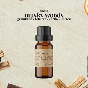 May include: A 15ml amber glass bottle of essential oil with a black cap and a tan label reading palo santo 100% pure essential oil blend 15ml aire candle. Above the bottle, text reads scent musky woods grounding tobacco earthy sacred.