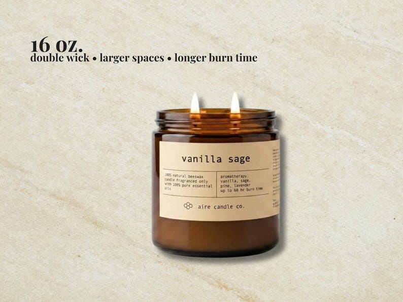 May include: A 16 oz. double wick candle in an amber glass jar with a beige label reading vanilla sage, 100% natural beeswax, aromatherapy: vanilla, sage, pine, lavender, up to 60 hr burn time, and aire candle co. Text above reads 16 oz. double wick.