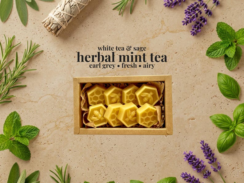 May include: A rectangular cardboard box filled with eight yellow hexagonal wax melts, each embossed with bee or honeycomb patterns. The text above reads white tea & sage herbal mint tea earl grey &bull; fresh &bull; airy, surrounded by sprigs of herbs.
