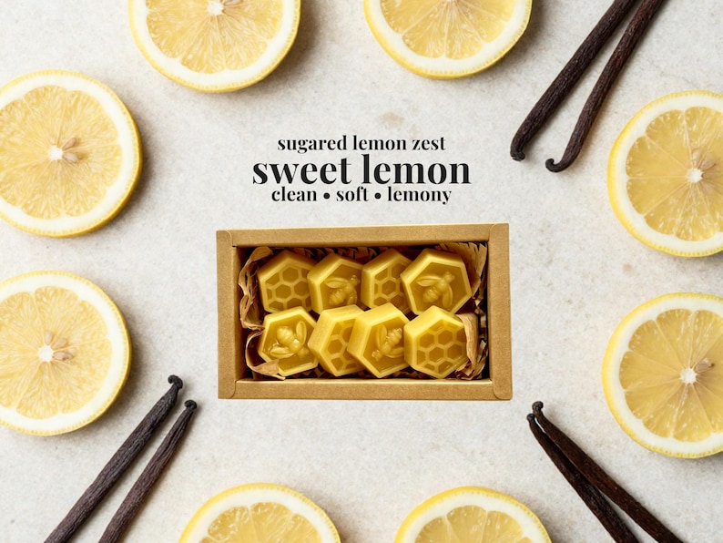 May include: A rectangular cardboard box containing eight yellow hexagonal wax melts, each embossed with bee or honeycomb patterns. The text above reads: sugared lemon zest, sweet lemon, clean, soft, lemony. The box is surrounded by lemon slices and vanilla beans.
