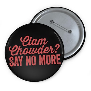 Puede incluir: Un botón negro con una inscripción roja que dice "Clam Chowder? SAY NO MORE".