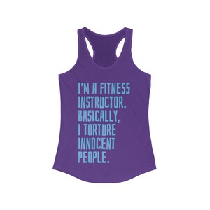 May include: A purple racerback tank top with the text "I'M A FITNESS INSTRUCTOR. BASICALLY, I TORTURE INNOCENT PEOPLE." in light blue. The tank top has a scoop neck and a racerback design.
