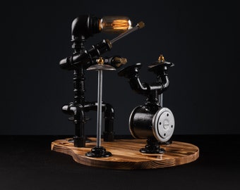 Peut inclure: Une lampe en métal noir en forme de batteur jouant sur une batterie. La lampe a une ampoule en forme de tête et une base en métal noir.