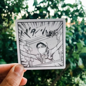 May include: Square sticker featuring a black and white manga panel. The panel depicts a character with a face covering, arms outstretched, and the word "CLATTER" in bold text. The background is a blurred green.