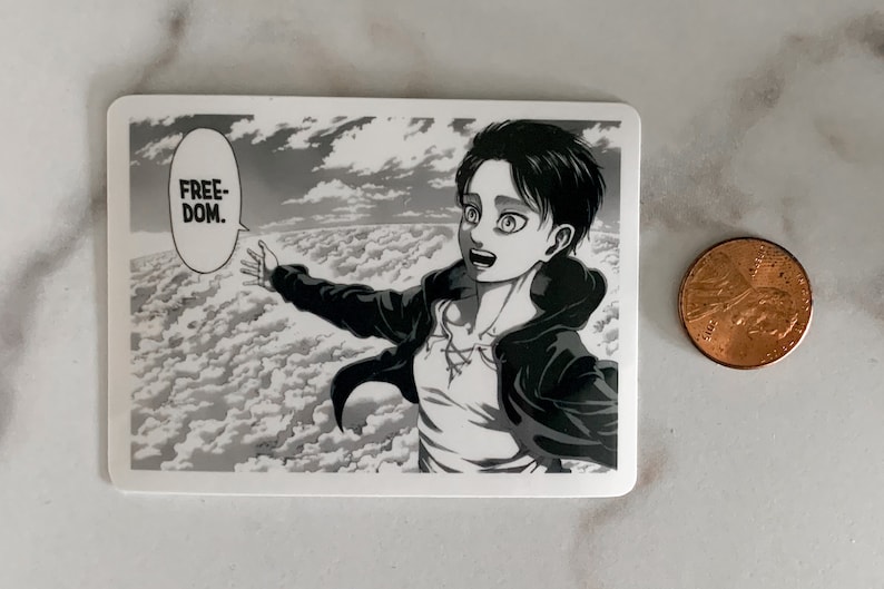 May include: A rectangular sticker featuring a black and white manga illustration of a character with outstretched arms, set against a cloudy sky. The word "FREEDOM" is in a speech bubble. A penny is next to the sticker.