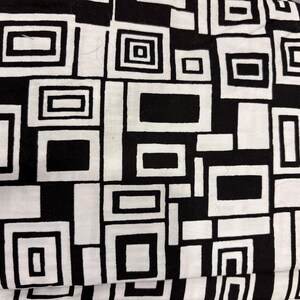 May include: Black and white geometric pattern fabric with a repeating design of squares and rectangles.