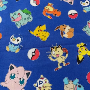 May include: Blue fabric with a repeating pattern of various Pokemon characters, including Pikachu, Bulbasaur, Squirtle, Charmander, and Jigglypuff. The characters are in a cartoon style and are surrounded by Poke Balls.