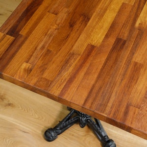 May include: A close-up of a wooden table top with a rich brown colour. The wood is arranged in a grid pattern, creating a unique and rustic look.