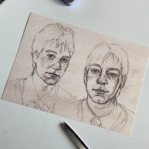 Puede incluir: Un dibujo a lápiz en blanco y negro de dos caras de hombres. Los hombres miran al espectador. El dibujo está en papel marrón claro.