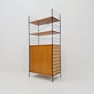 May include: A black metal shelving unit with wooden shelves and a cabinet with two doors. The unit has a modern design and is ideal for storing books, decor, or other items.