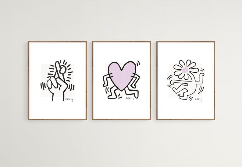 May include: Three framed prints of black and white line drawings by artist Keith Haring. The first print features a hand with crossed fingers, the second print features a heart-shaped figure with legs, and the third print features a figure with a daisy for a head.