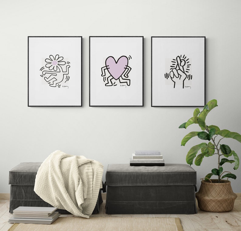 May include: Three framed black and white prints of artwork by Keith Haring. The prints feature a flower, a heart, and a hand. Each print has the artist's signature and the word "K. Haring" in the bottom right corner.