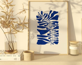 May include: A framed print with a blue abstract design of a stylized plant on a white background. The print is on a shelf with a vase of dried flowers and a wooden candle holder.