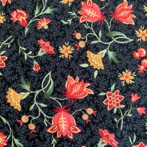 Może przedstawiać: Zbliżenie tkaniny z granatowym tłem i kwiatowym wzorem. Wzór przedstawia czerwone, pomarańczowe i żółte kwiaty z zielonymi liśćmi i łodygami. Kwiaty mają różne rozmiary i kształty, tworząc atrakcyjny wizualnie design.