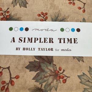 May include: Fabric bundle with a repeating pattern of green leaves and red berries on a tan background. The text "A Simpler Time" is printed on a white label, along with the "moda" logo and the designer's name.