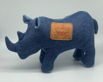 May include: A blue denim rhinoceros plush toy with a Levi Strauss & Co. label on its side. The label is brown with red text and features a horse-drawn wagon.