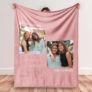 May include: A dusty rose-colored blanket with two photo collages. The top collage reads "BETTER TOGETHER" and features two women. The bottom collage reads "EMILY & GRACE" and features two women. The blanket is held up by a person.