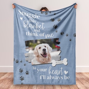May include: A blue fleece blanket with paw prints and the text "Snuggle this blanket and think of me. In your heart I'll always be." A photo of a golden retriever is in the center of the blanket with the name "Rocky" written below the photo.