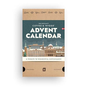 Puede incluir: Una caja de calendario de Adviento de cartón con un diseño temático de Copenhague. La caja presenta el texto "ADVENT CALENDAR" y "A TRIBUTE TO WONDERFUL COPENHAGEN". La caja es neutra en plástico y neutra en CO2.