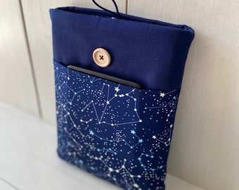 Könnte beinhalten: Eine marineblaue Stoffhülle mit einem Sternbildmuster. Die Hülle hat eine marineblaue Oberseite mit Knopfverschluss und Schlaufe. Eine kleine Tasche enthält ein schwarzes Objekt.