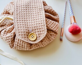 Neceser redondo con cordón: bolsa de viaje de tela gofrada