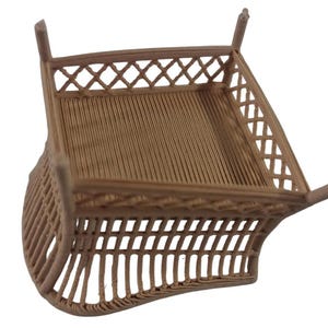 May include: A light brown, 3D-printed miniature square basket or container featuring a textured, ribbed base and a decorative lattice-style fence around the top perimeter, supported by four small, vertical corner posts extending upwards.