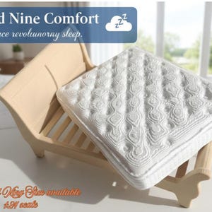 May include: A miniature wooden bed frame with a white quilted mattress. The blue banner at the top displays the text Cloud Nine Comfort Experience revolutionary sleep. The bottom text reads Queen and King Size available 1:24 scale.