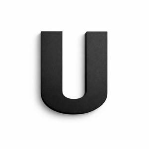 May include: A black, three-dimensional letter "U" against a white background. The letter has a textured surface and casts a subtle shadow, giving it a sense of depth. The design is simple and modern.